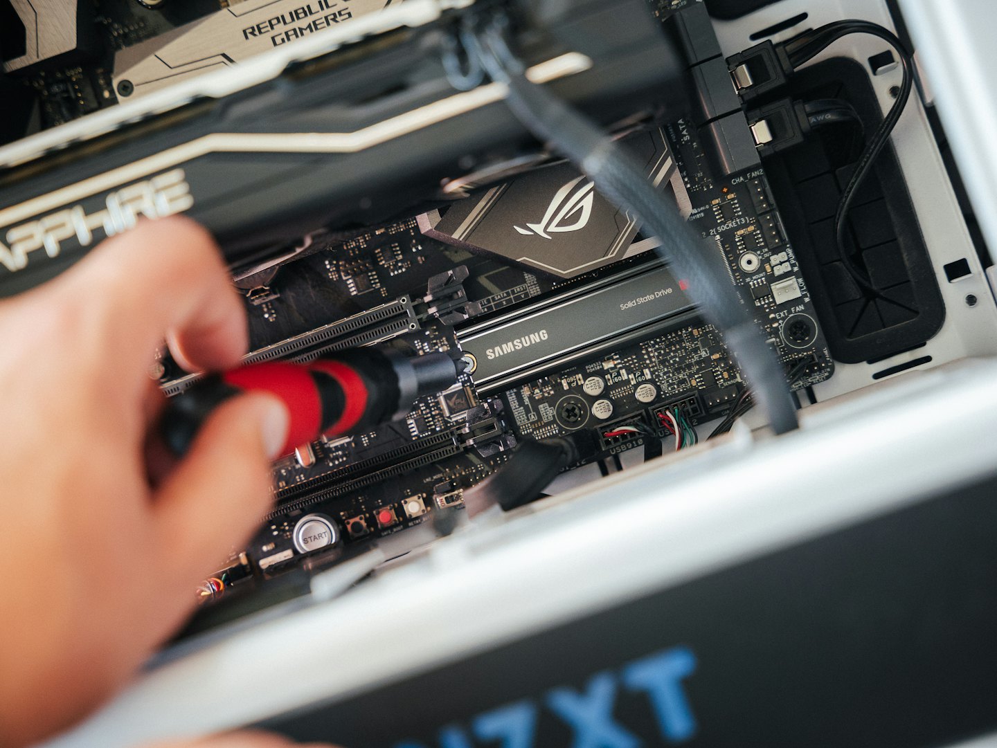 Une main utilise un tournevis pour assembler des composants d'ordinateur.